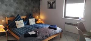 ein Schlafzimmer mit einem Bett mit blauen Kissen und einem Fenster in der Unterkunft Pension Deerkemer Kuh in Dorn-Dürkheim
