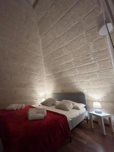 a bedroom with a bed with a brick wall at B&B LE CUSPIDI in Ginosa