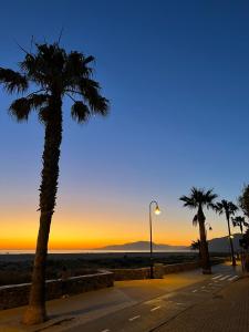 uma palmeira e uma luz de rua ao pôr-do-sol em TarifaMiCasa Mar Tirreno em Tarifa