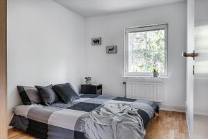 a white bedroom with a bed and a window at Uppsala Large family home beside forest in Uppsala