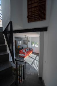 uma sala de estar com um sofá laranja e uma escada em Beachhouse with amazing terrace next to the ocean em Bocacangrejo