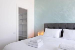 a bedroom with a white bed with towels on it at Tel Aviv Vacation Apartments in Tel Aviv