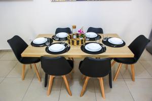 mesa de madera con sillas negras y comedor en Beatrix Home, en Catania