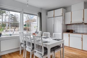 a kitchen with a white table and chairs and a window at Uppsala Large family home beside forest in Uppsala