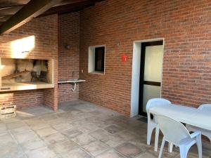 a brick wall with a table and chairs on a patio at Casa Picaflor UY in Jaureguiberry