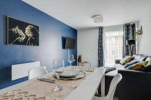een eetkamer met een tafel en een blauwe muur bij City Living Penthouse Apartment with Parking (Manchester) in Manchester