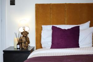 a bed with a brown headboard and a lamp on a table at Berry's Loft - Central Location and Fast WIFI in Knaresborough