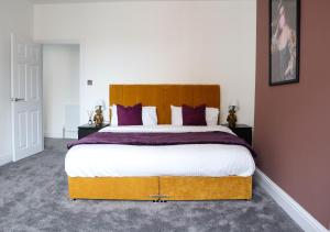 1 dormitorio con 1 cama grande con almohadas moradas en Berry's Loft - Central Location and Fast WIFI, en Knaresborough