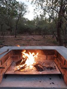 a fire pit in the middle of a field at Villa de Leeu, Perfect for Two in Marloth Park