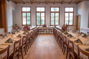 a banquet hall with long tables and chairs at 3 Sterne Boutique Gasthaus Pöstli in Rifferswil
