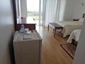 Habitación con cama y mesa con botellas de agua en Agroturismo A Fidalga, en Linhares