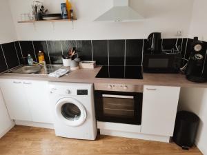 a kitchen with a washing machine and a sink at Maison scandinave avec garage in Roubaix