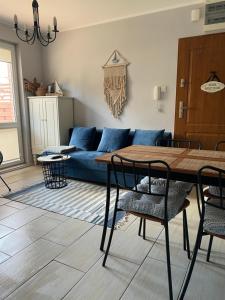 ein Wohnzimmer mit einem blauen Sofa und einem Tisch in der Unterkunft Apartament Maki Apartament na wyłączność in Krynica Morska