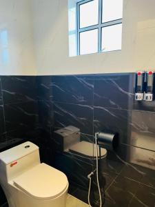 La salle de bains est pourvue de toilettes et d'une fenêtre. dans l'établissement Inn Homestay 1st Floor Unit, à Teluk Intan
