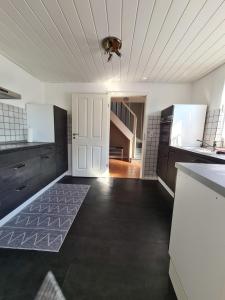 eine Küche mit schwarzen Schränken und einer weißen Decke in der Unterkunft Schiefer Huus in Krummhörn