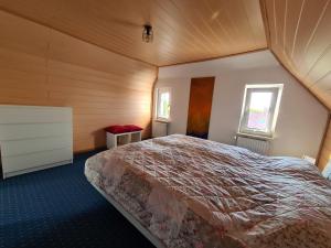 ein Schlafzimmer mit einem großen Bett in einem Zimmer in der Unterkunft Schiefer Huus in Krummhörn