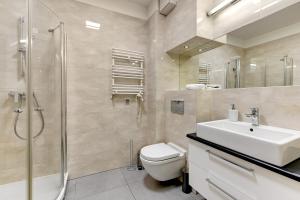 a bathroom with a toilet and a sink and a shower at Apartament Neptun Park Gdansk Jelitkowo by Grand Apartments in Gdańsk