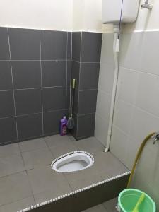 een betegelde badkamer met een toilet in een stal bij Myra Anne Home2Stay Alor Gajah Melaka in Kampong Dalong