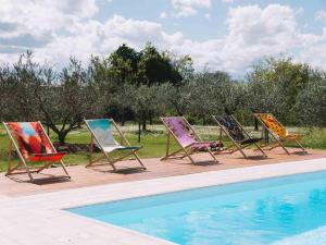 une rangée de chaises longues assises à côté d'une piscine dans l'établissement Podere Selvatici, à Imola