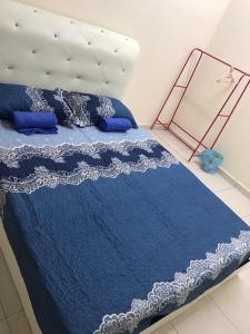 a bed with a blue comforter and blue pillows at Myra Anne Home2Stay Alor Gajah Melaka in Kampong Dalong