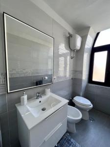 a bathroom with a sink and a toilet and a mirror at Gragnano_roomandapartment in Gragnano
