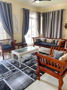 a living room with a couch and a table and chairs at Mbweni Raffia Apartment in Kiembi Samaki