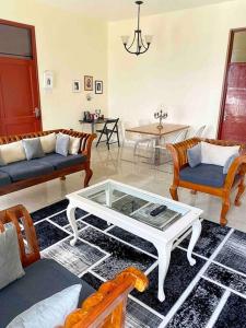 Sala de estar con sofás y mesa de centro en Mbweni Raffia Apartment en Kiembi Samaki