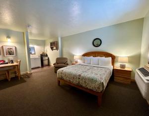 a bedroom with a bed and a desk and a chair at Mt Gardner Inn in Winthrop