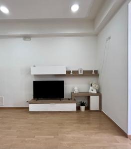 a living room with a flat screen tv on a white wall at Gragnano_roomandapartment in Gragnano