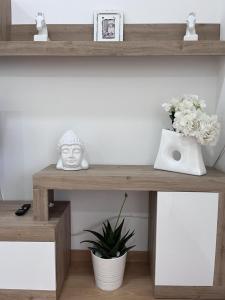a wooden shelf with a vase of flowers on it at Gragnano_roomandapartment in Gragnano +14 photos