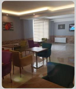 - un restaurant avec des tables et des chaises dans une salle dans l'établissement Akademi Suit, à Eskişehir