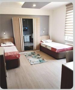 a bedroom with two beds and a mirror at Akademi Suit in Eskisehir