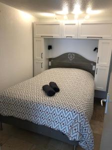 ein Schlafzimmer mit einem Bett mit zwei schwarzen Schuhen darauf in der Unterkunft Havre de paix aux portes de la Provence Verte in Forcalqueiret