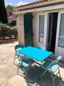einen blauen Tisch und Stühle vor einem Haus in der Unterkunft Havre de paix aux portes de la Provence Verte in Forcalqueiret