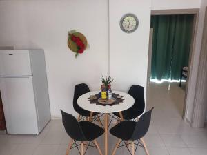 uma cozinha com uma mesa com cadeiras e um frigorífico em Hibiscus Green Appartments 1 em Afantou