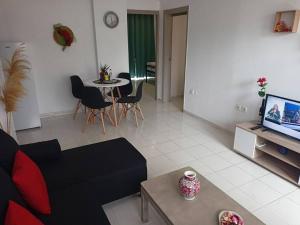 a living room with a couch and a table at Hibiscus Green Appartments 1 in Afantou