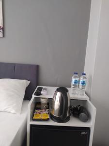 Zimmer mit einem Bett, einem Wasserkocher und Wasserflaschen in der Unterkunft THE LİMA SUİTES KADIKÖY in Istanbul