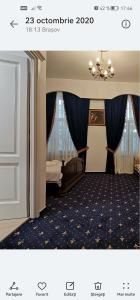 Habitación de hotel con cama y lámpara de araña. en Weiss Little Palace, en Brasov