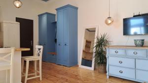 een kamer met blauwe kasten en een spiegel bij Home away from home in Tbilisi City
