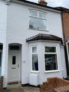 a white house with a white door and windows at House for Contractors and Families in Aldershot