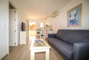 uma sala de estar com um sofá e uma mesa em Apartamentos Turísticos Gran Sol em Zahara de los Atunes