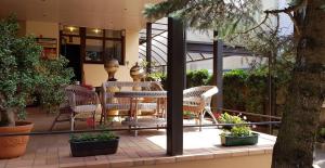 a patio with a table and chairs and plants at Antano Vila in Palanga