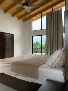 - une chambre avec un grand lit et une grande fenêtre dans l'établissement Villa mi paz, à Jarabacoa