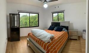 - une chambre avec un lit et 2 fenêtres dans l'établissement Villa mi paz, à Jarabacoa