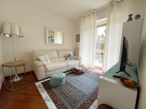 a living room with a white couch and a television at Casa Corallo Vicino alle Spiagge in Sanremo