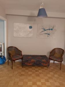 ein Wohnzimmer mit 2 Stühlen und einem Sofa in der Unterkunft Apartamento a 15 minutos del centro in Madrid