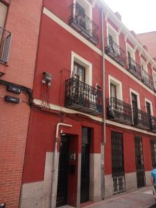 un edificio rojo con balcones en una calle en Habitación en Madrid, en Madrid