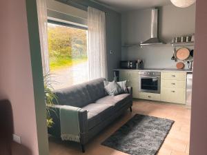 a living room with a couch in front of a window at The Blue Door Apartment in Cahersiveen