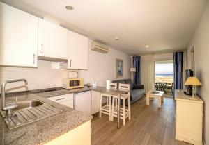a kitchen and living room with a couch at Apartamentos Turísticos Gran Sol in Zahara de los Atunes
