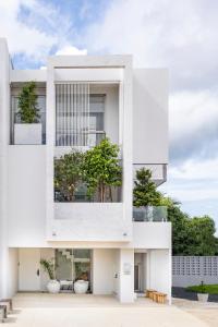 a white building with a tree in the middle at Luxury 3 Bedrooms Villa Bangtao in Ban Pa Khlok